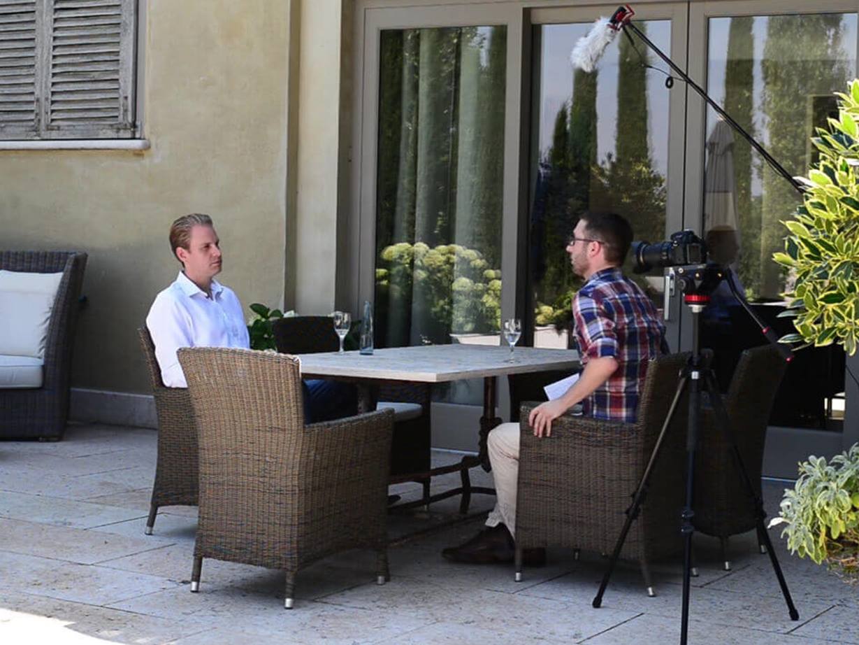 Alexander Teepe und Interviewpartner sitzen an einem Tisch