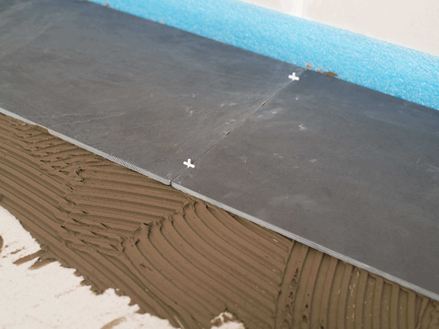 Fugenkreuze als Abstandshalter zwischen zwei Schieferfliesen