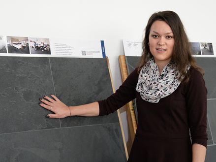 Mitarbeiterin steht vor Mustertafeln mit Schiefer