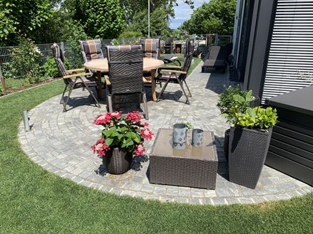 Pflastersteine Gneis Urban Grey Line im Grnen mit Blumen