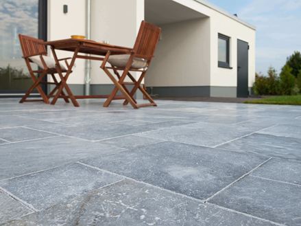 Froschperspektive auf Terrasse mit Marmorplatten und Holzmöbeln