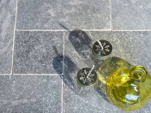 Vase und Gläser stehen auf grauen Marmorplatten im Römischen Verband