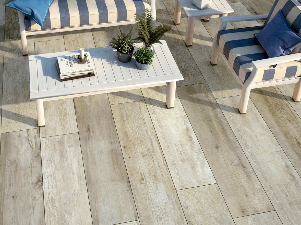 Lounge-Ecke zum Entspannen Terrasse mit weißen Gartenmöbeln und Holzoptikplatten von oben fotografiert