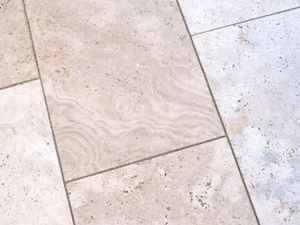 Sanften Maserungen verleihen edlen Charme. Nahaufnahme Travertin Platten für den Aussenbereich in zartem Beige