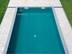Pool umrandet von hellen Travertinplatten aus der Luft fotografiert