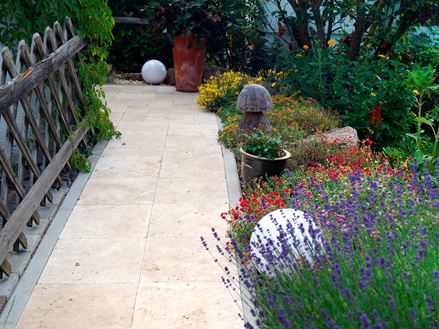 Gartenweg mit Holzzaun und wildem Beet aus Travertin Medium Select