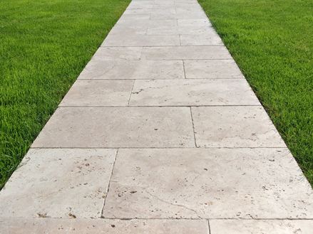 Gehweg aus Travertinplatten auf Rasen