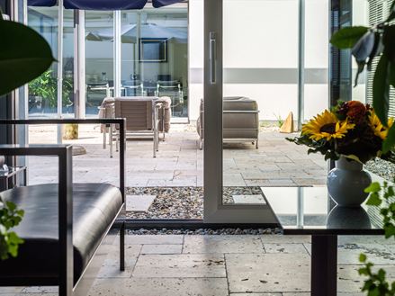 Wintergarten mit Natursteinplatten Travertin Rustic und moderner Einrichtung