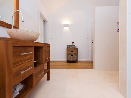 Badezimmer mit Holzmöbeln und Kalksteinfliesen Cleopatra Light