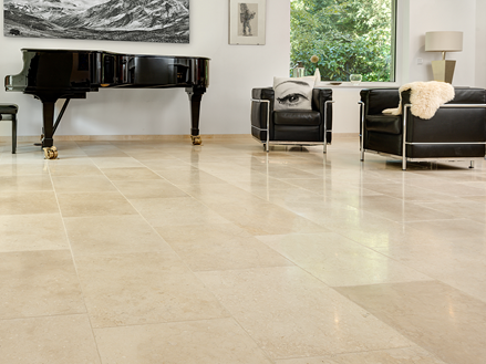 Helles Wohnzimmer mit beigem Kalkstein als Bodenbelag, modernen Couchmöbeln und einem Flügel