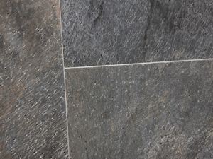 Verlegte Quarzitfliese in schimmernden Grüntönen mit schmalen hellen Fugen