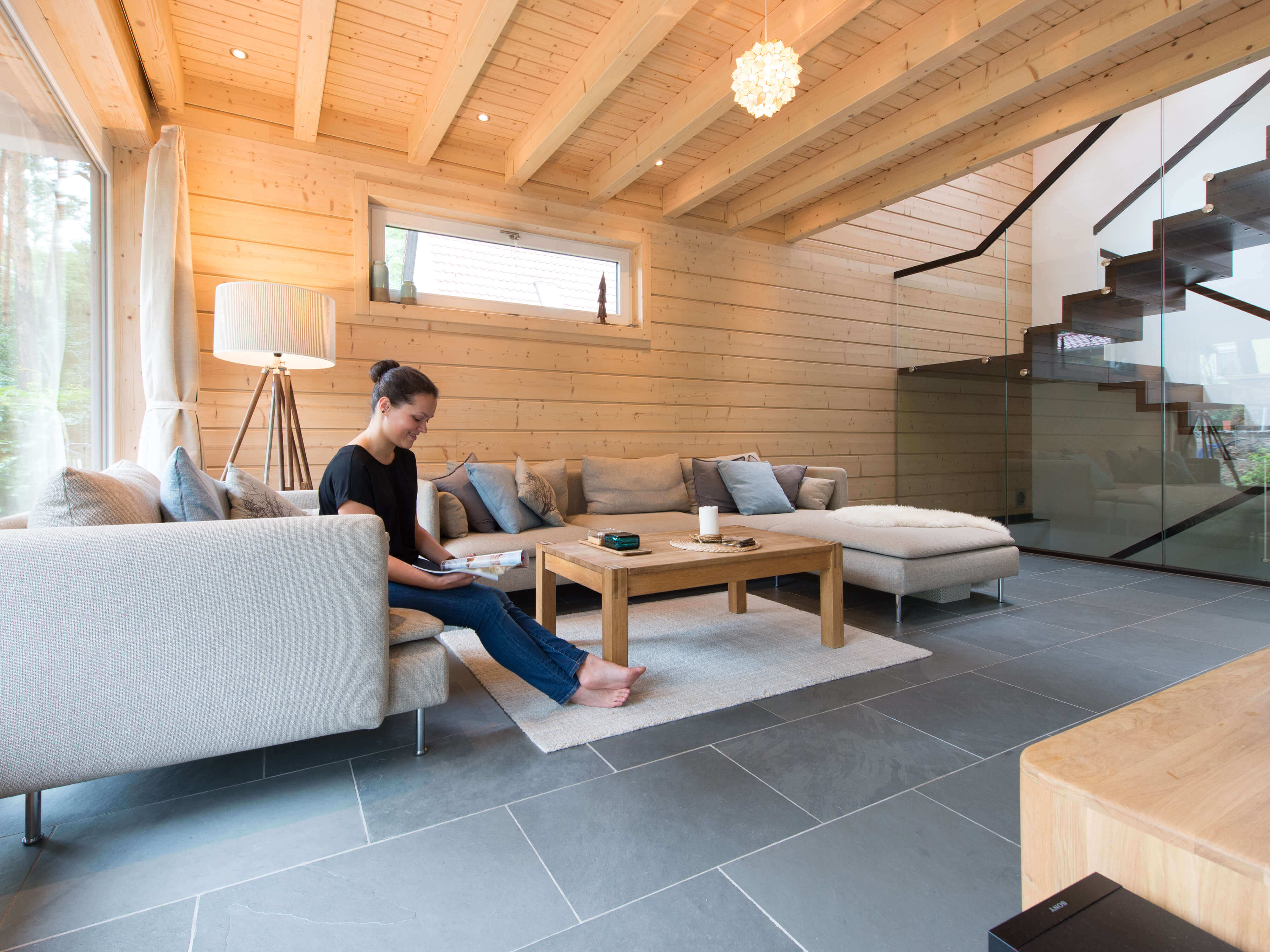 Frau im Wohnzimmer mit Schieferfliesen Grey Slate und Holzwand