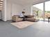 Grossformatige Schieferfliese Grey Slate im Wohnzimmer mit heller Couch und weissen Wänden. Ein Paar sitzt auf der Couch