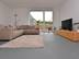 Wohnzimmer mit beigefarbener Couch, beigefarbenen Teppich und Fernsehtisch aus Holz auf Schiefer Grey Slate im Grossformat