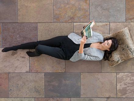 Frau liegt auf Buntschiefer Fliesen Peacock Multi Color und liest