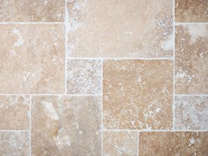 Vogelperspektive auf verlegte und verfugte Travertinfliesen in Beige und Braun