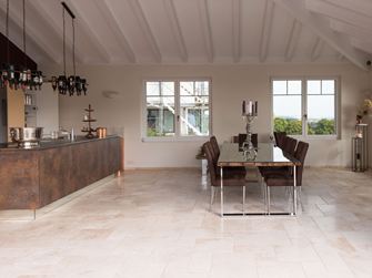 Travertinfliesen Light im Römischen Verband in einer modernen Küche mit Esstisch und Kochinsel