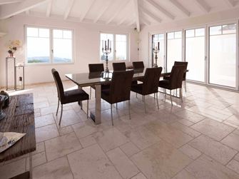 Esszimmer mit hoher Decke, Tisch und Stühlen auf Travertin Light in römischem Verband