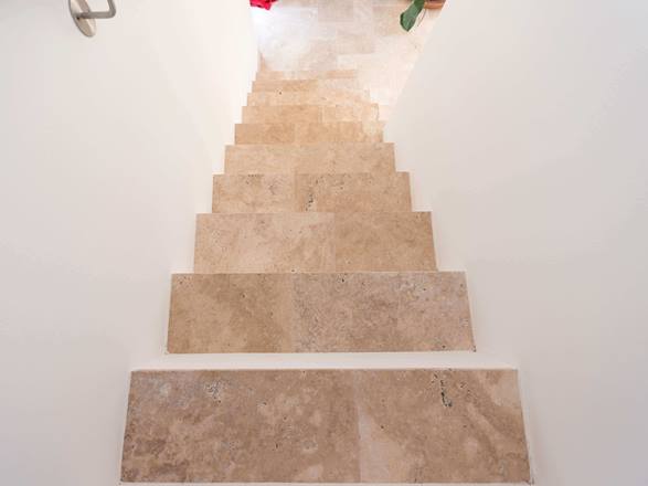 Travertin Medium auf der Treppe. Hier mit Fuge. Treppe mit weissen Wänden und Travertin Medium als Trittplatten