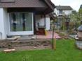 Terrassenbaustelle an einem Haus, im Vordergrund eine Rasenfläche