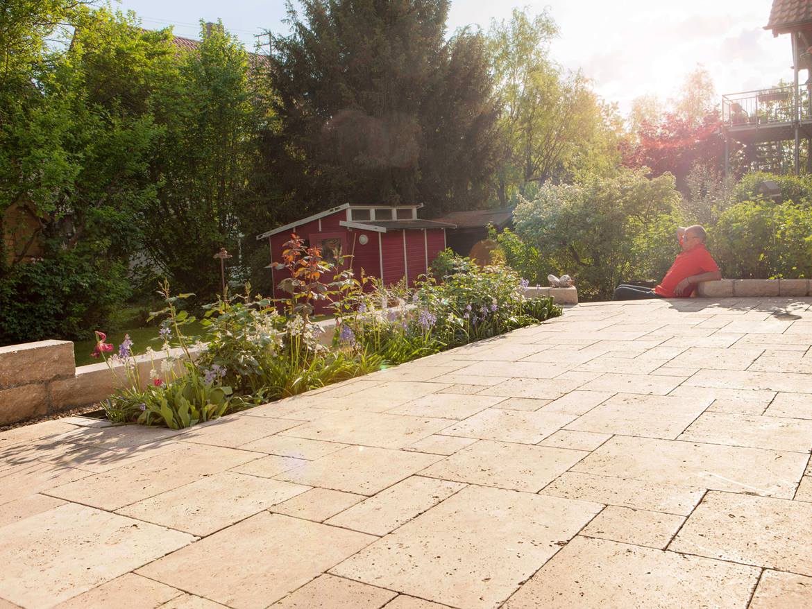 Terrasse aus Travertinplatten Medium Select mit Garten im Hintergrund