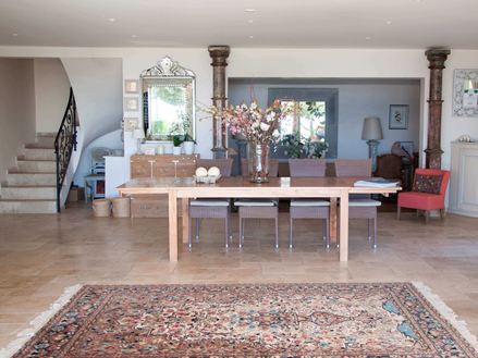 Eingangsbereich eines Hotels mit persischem Teppich und Holztisch auf Travertinfliesen