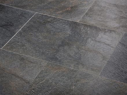 Nahaufnahme von verlegten Natursteinfliesen in dunklem Anthrazit mit bunten Farbnuancen