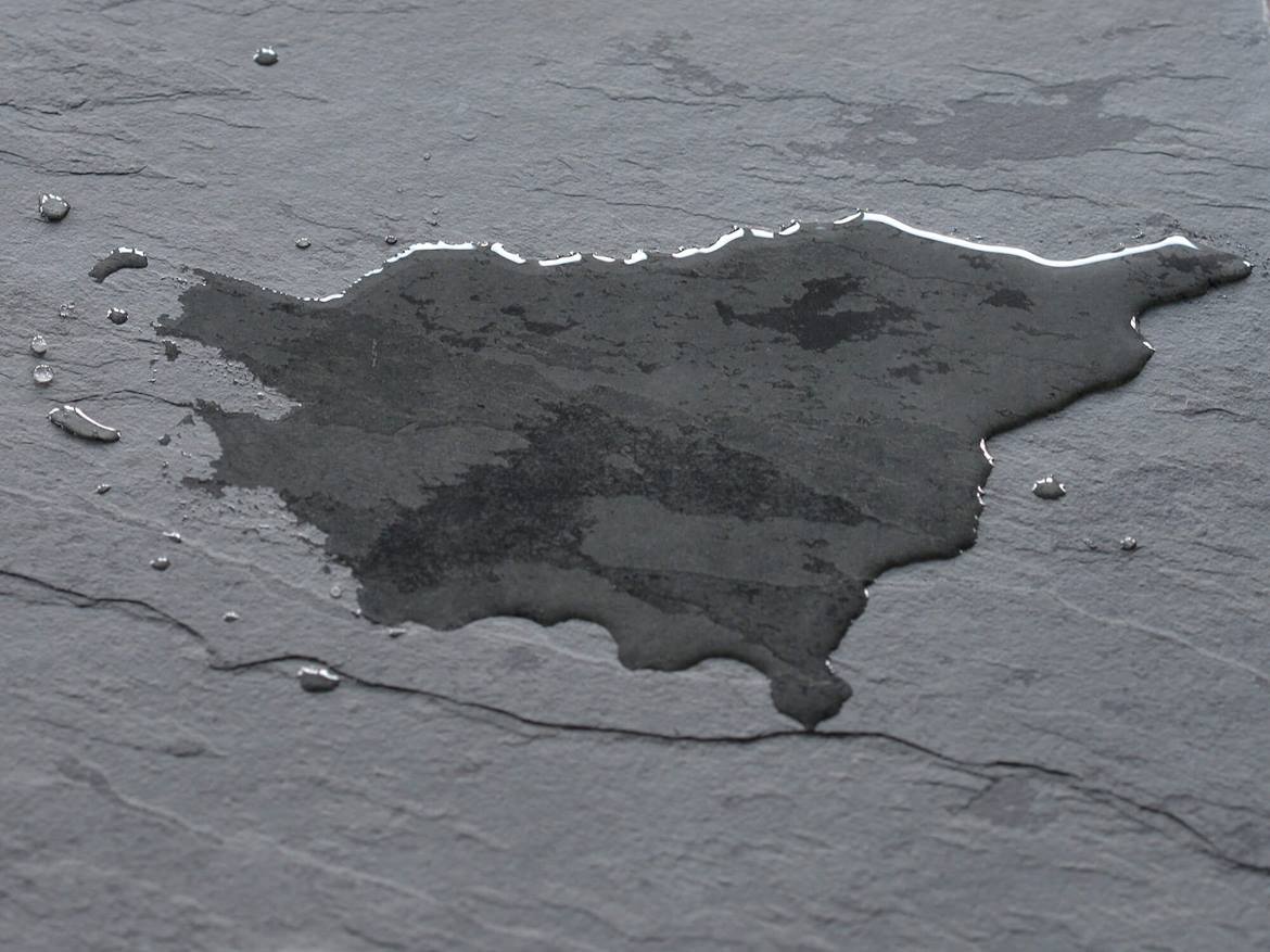 Dunkle Schieferfliese mit Wasserlache