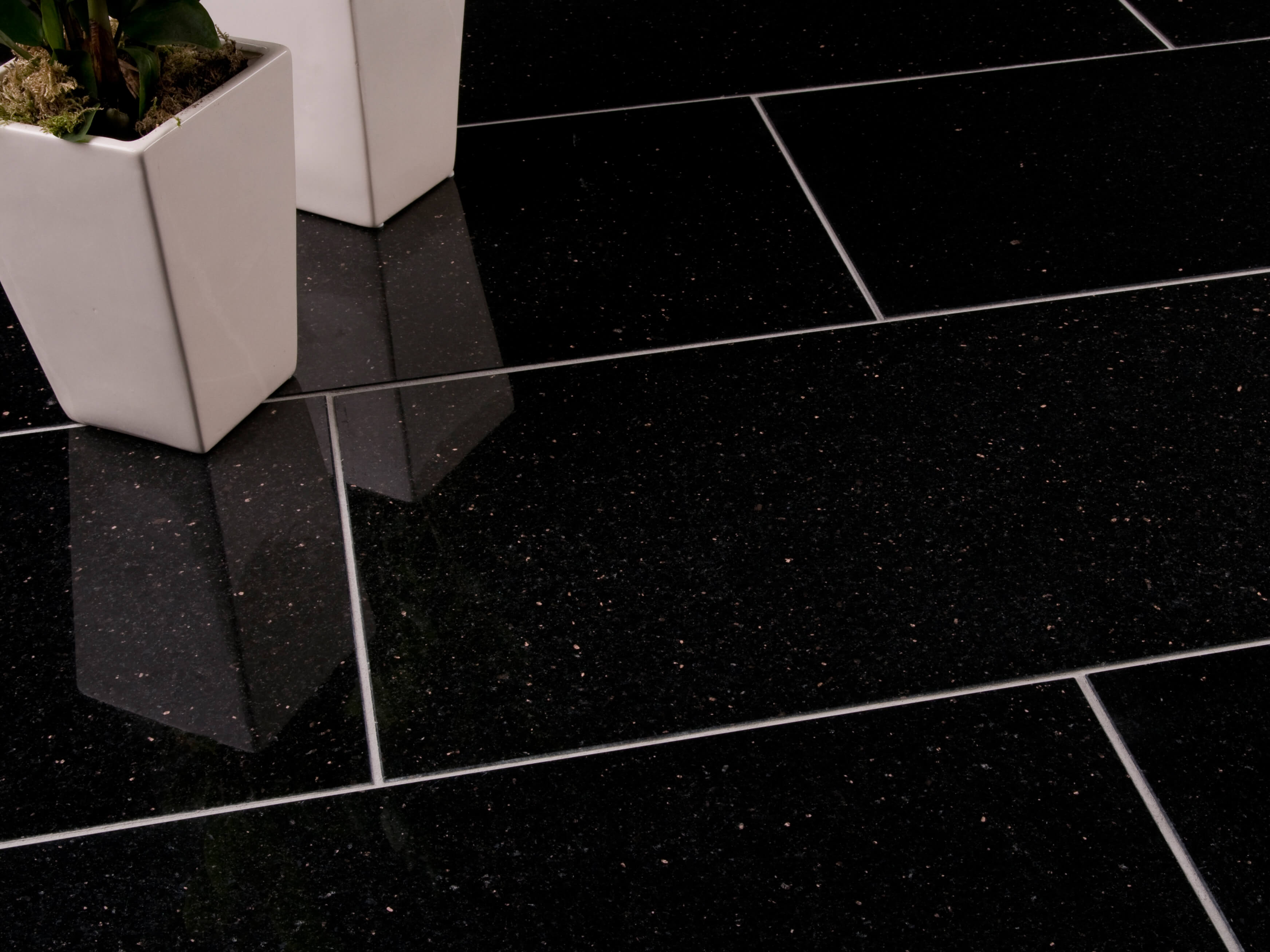 Zwei weiße Blumenkübel auf dunklen Granitfliesen Star Galaxy mit schmalen hellen Fugen