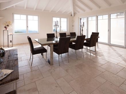 Esszimmer mit hoher Decke, Tisch und Stühlen auf Travertin Light in römischem Verband