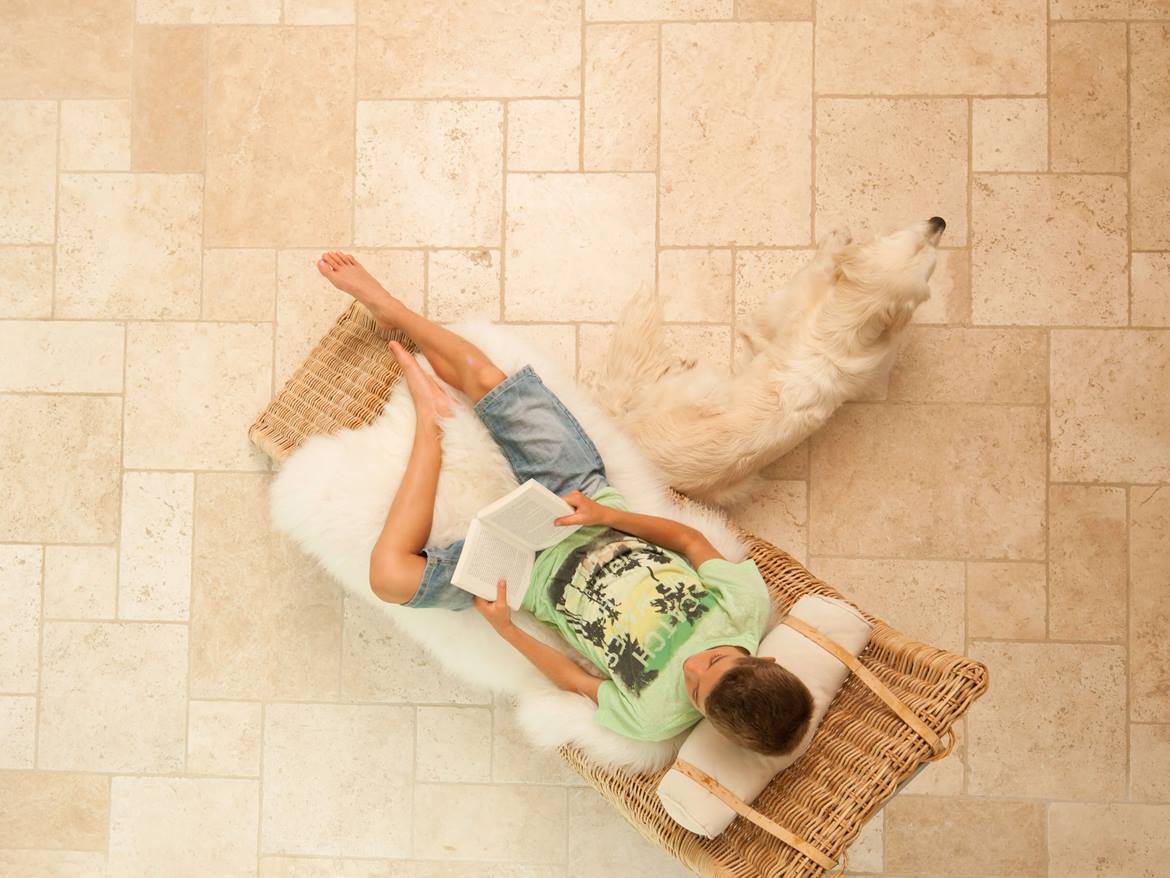 Zwei Kinder mit Golden Retriever auf Travertinfliese Light