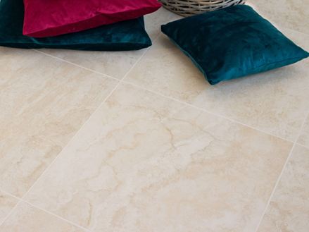 Bunte Kissen auf Feinsteinfliesen in heller Travertinoptik