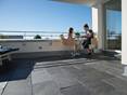 Frau und Kind sitzen an einem Tisch auf der Dachterrasse mit Naturschiefer