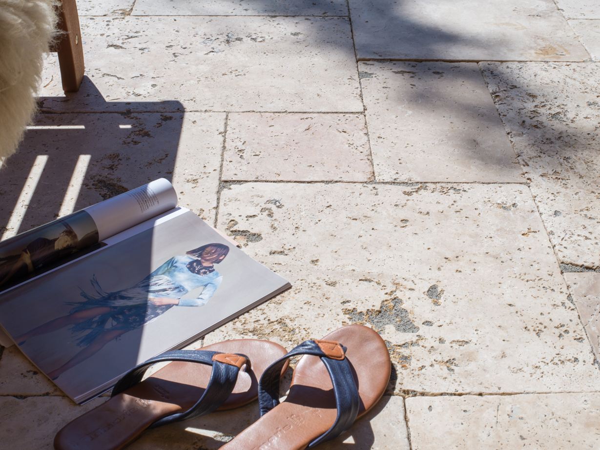 Zeitschrift und Schuhe auf Travertinterrasse Rustic