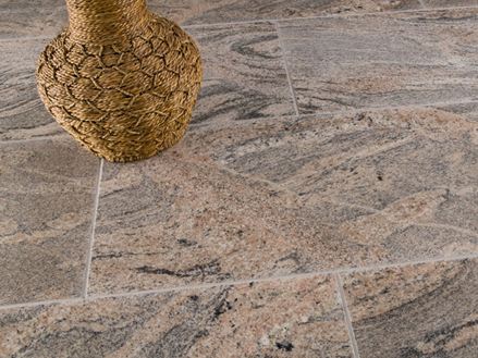 Fliesen Juparana Colombo in Rot-Grau mit einer braunen Dekovase