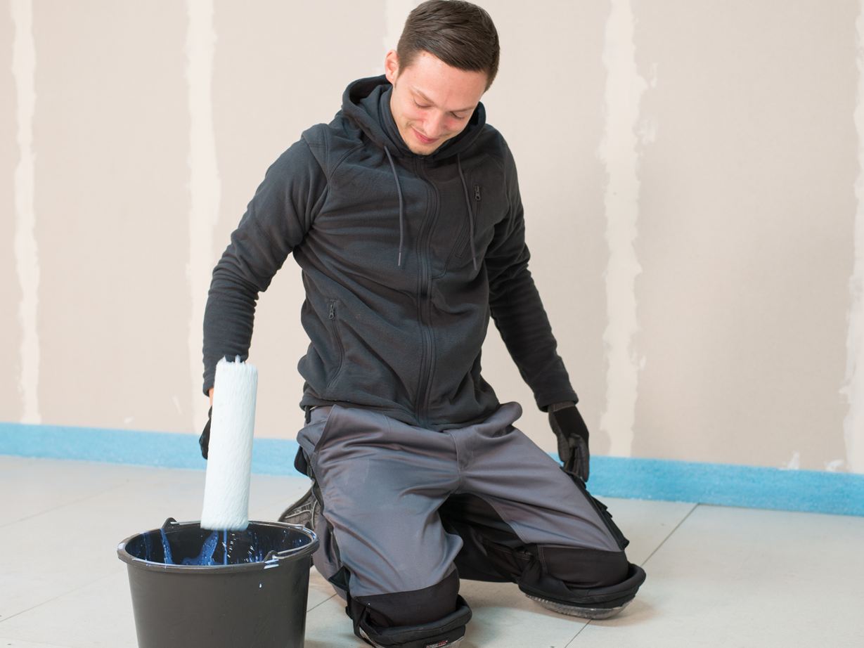 Fliesenleger grundiert den Boden