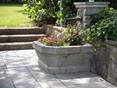 Der Sandstein eignet sich auch für eine natürliche Gartengestaltung Sandsteinplatte in Grau Kandla Grey Brunnen mit Blumen