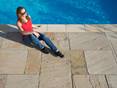 Sommer, Sonne, Sandstein: Mit dem Yellow Mint bringen Sie den Urlaub in Ihren Natursteingarten! Abendsonne auf den Sandsteinplatten Yellow Mint mit Frau am Pool