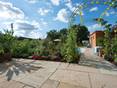Traumhafter Natursteingarten mit Yellow Mint Helle Platten aus Sandstein Yellow Mint mit naturnahem, mediterranem Garten im Hintergrund