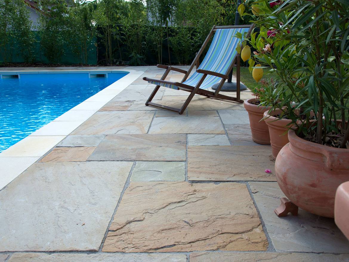 Liegestuhl am Pool, Bodenbelag aus beigem Sandstein
