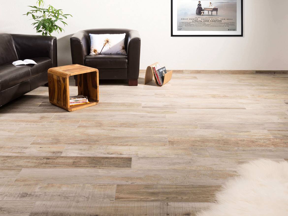 Naturnahes Wohnzimmer mit Ledersofa und Holzoptifliesen aus Feinsteinzeug