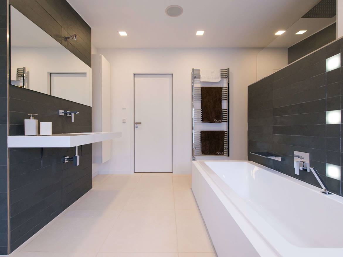 Bad mit Badewanne, Wandverkleidung aus Schiefer und hellem Kalkstein Miros als Bodenbelag