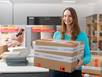 Mitarbeiterin mit Musterpaket in der Hand