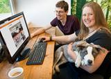 Mitarbeiter am Schreibtisch mit Hund auf dem Schoß